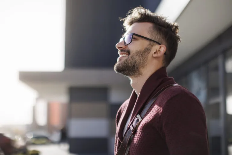 Portrait of young happy man contemplating outdoors